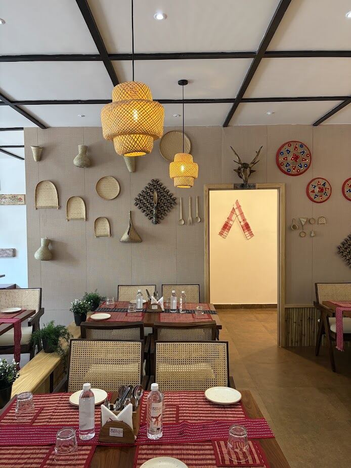 Aakhol Hyderabad interior — cane chairs, handwoven wall decor, warm lighting