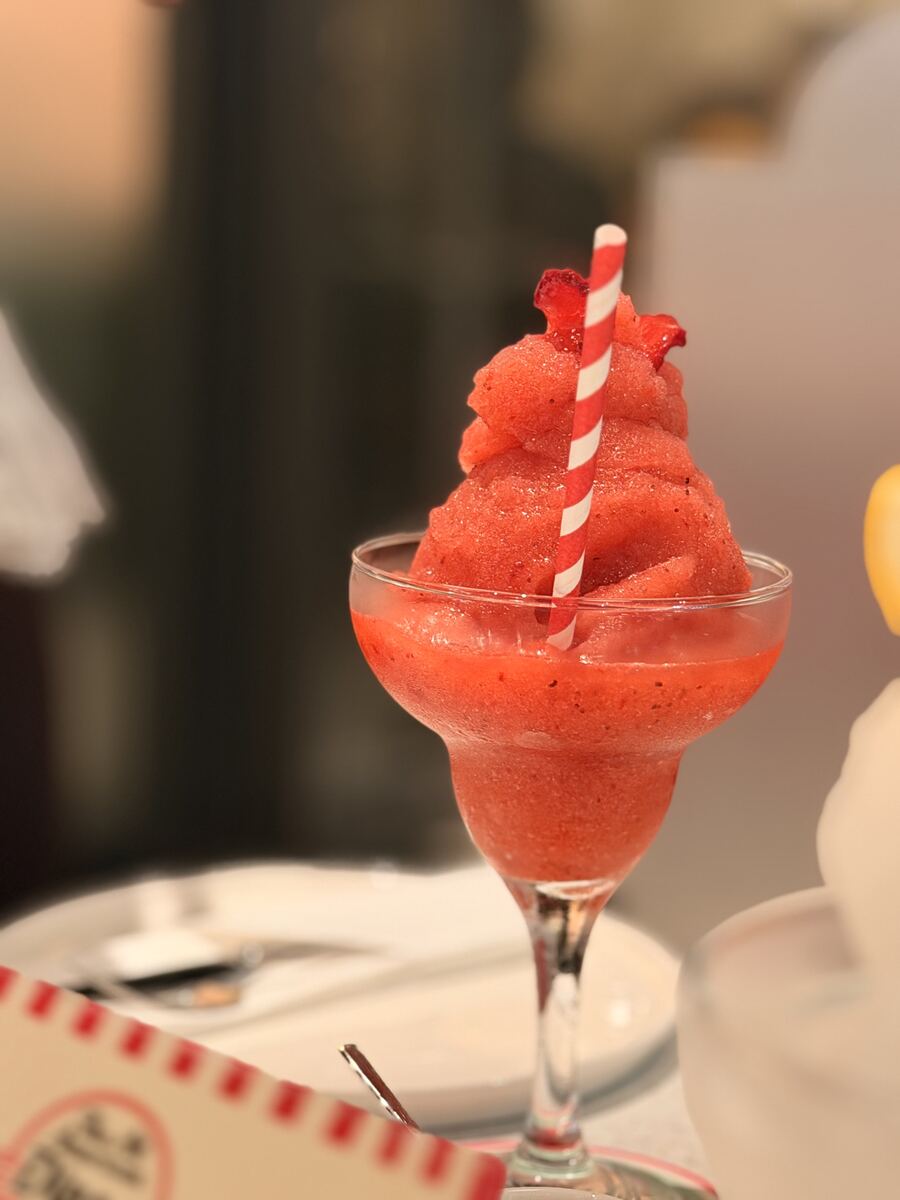 Strawberry frozen cocktail with a striped paper straw at the All American Diner Hyderabad