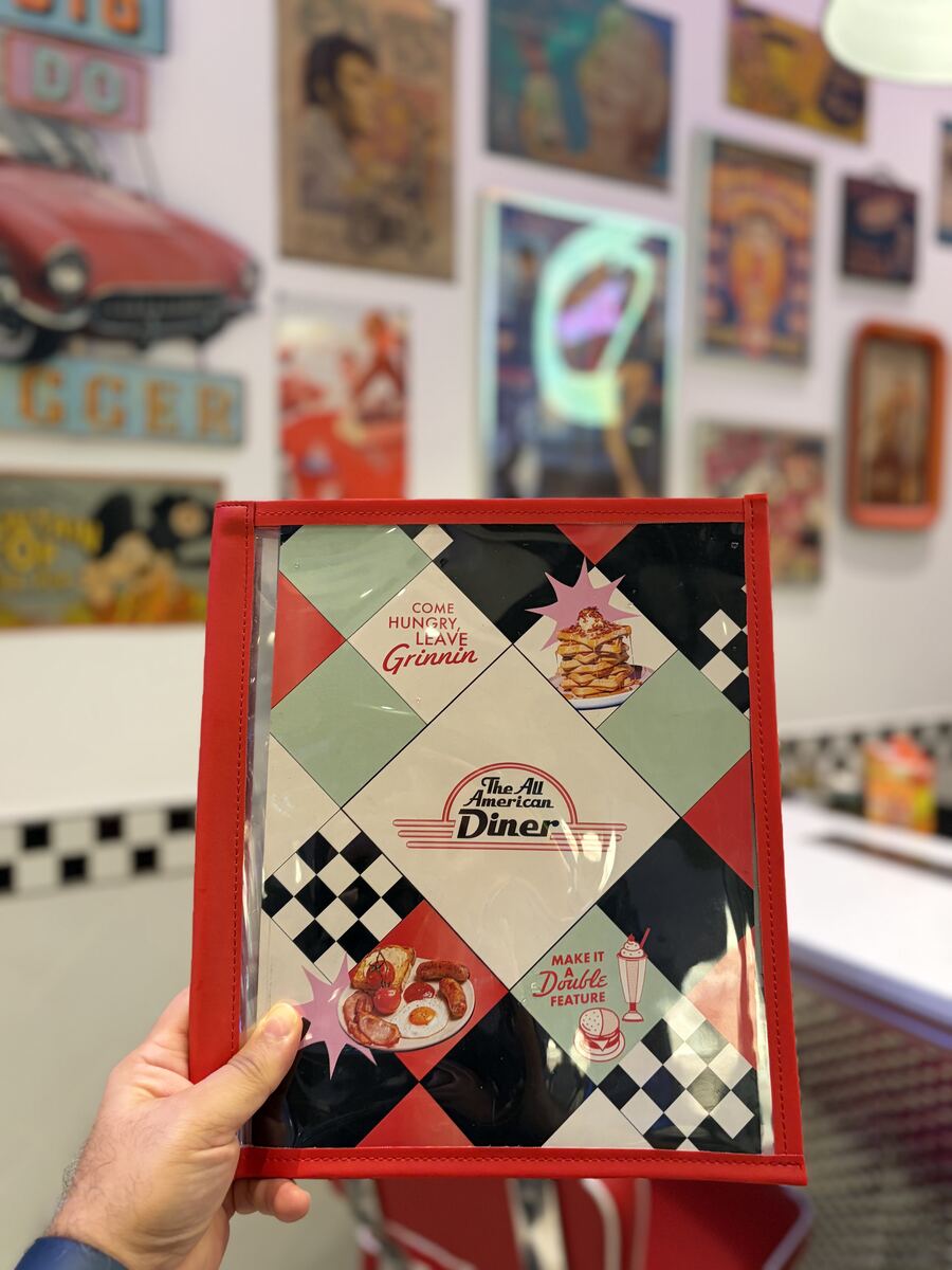 The All American Diner menu cover reading Come Hungry Leave Grinnin with checkerboard design