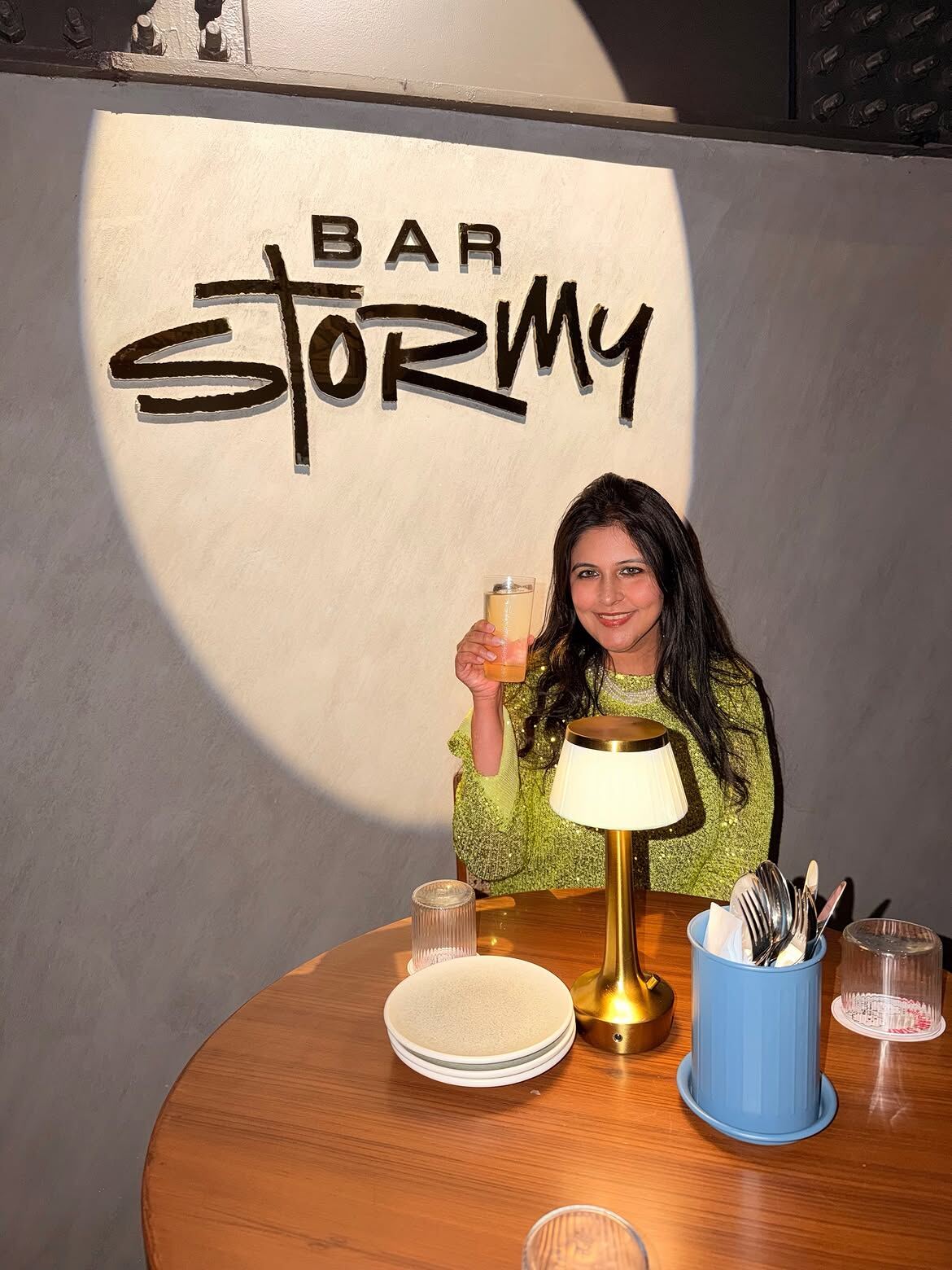 Reema at Bar Stormy, Financial District, Hyderabad, under the Bar Stormy sign with a signature cocktail