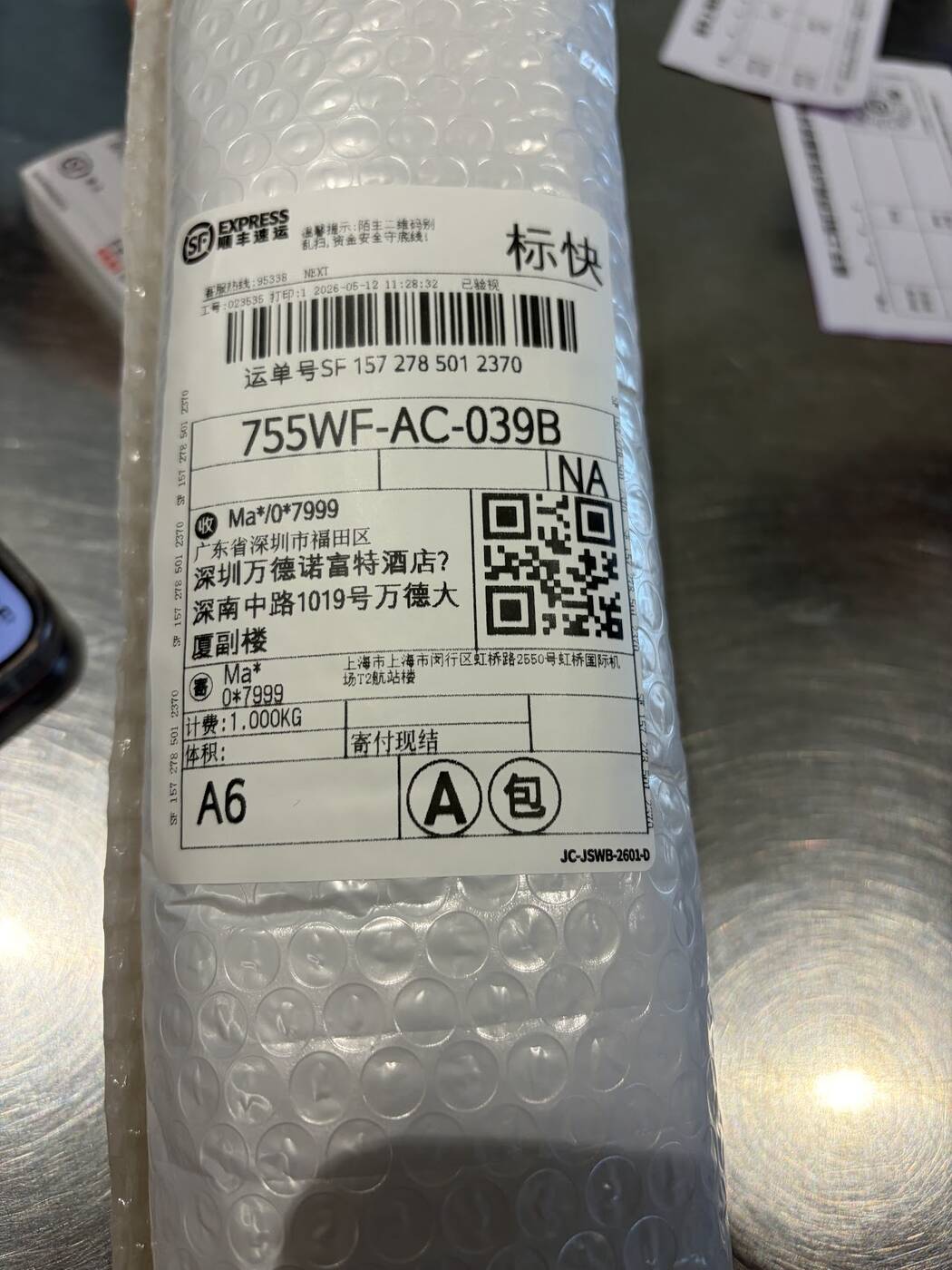 SF Express shipping label and bubble-wrapped parcel addressed to a hotel in Shenzhen
