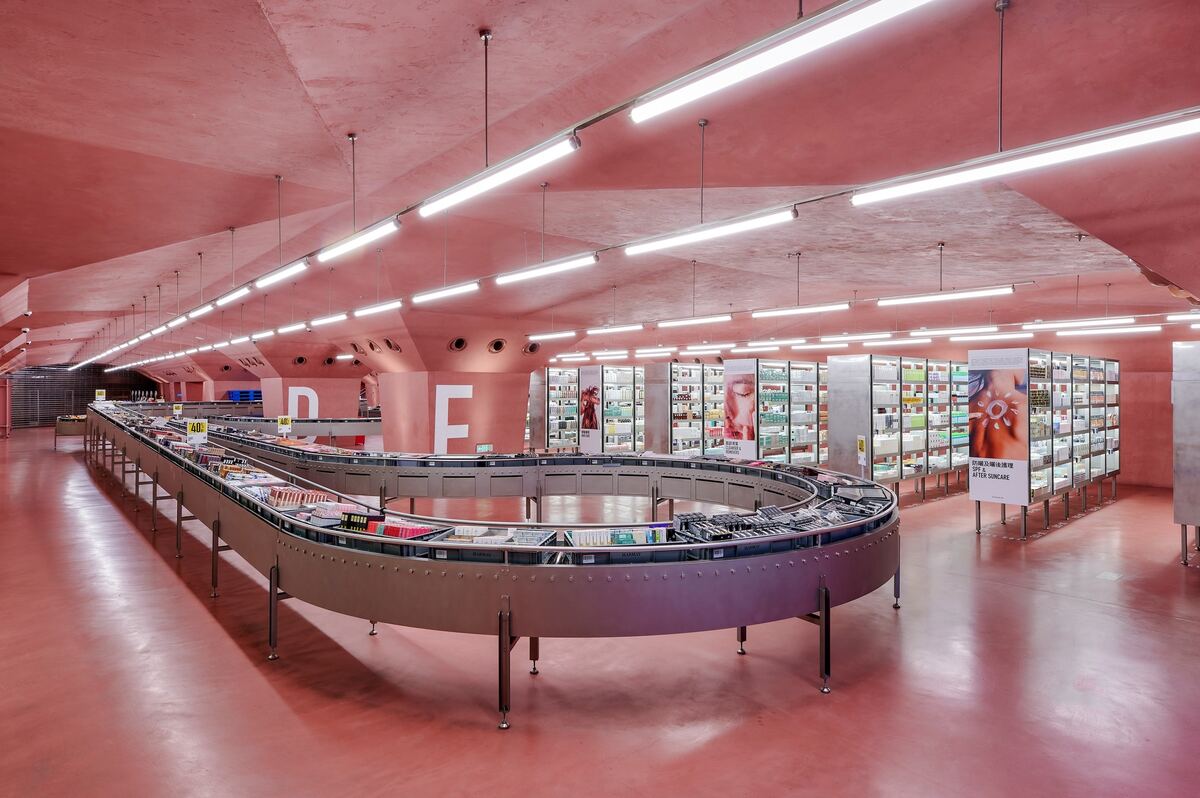Inside the HARMAY store in Chongqing, with a pink concrete ceiling and a looping conveyor of beauty products