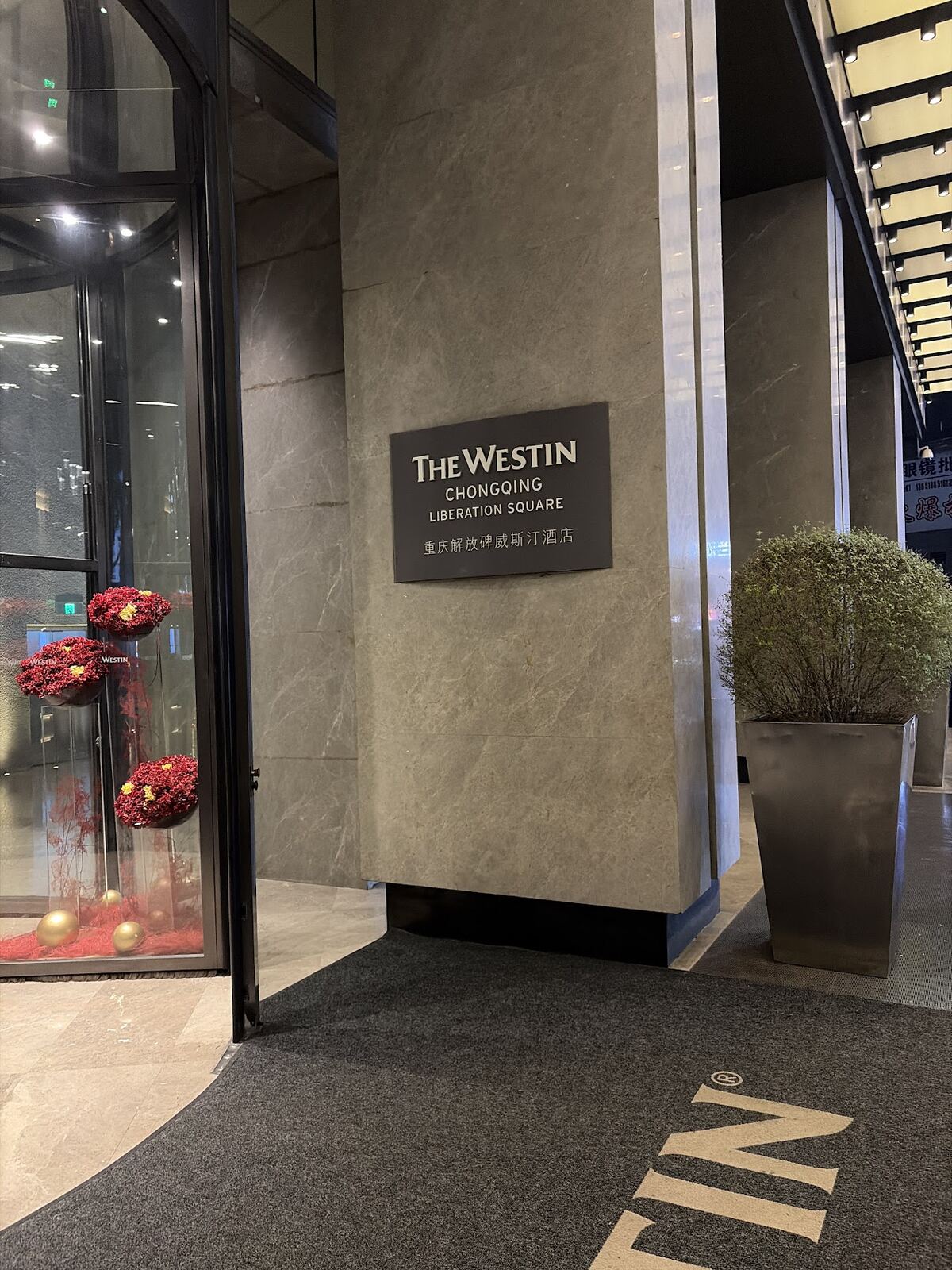 The Westin Chongqing Liberation Square entrance sign beside the revolving door