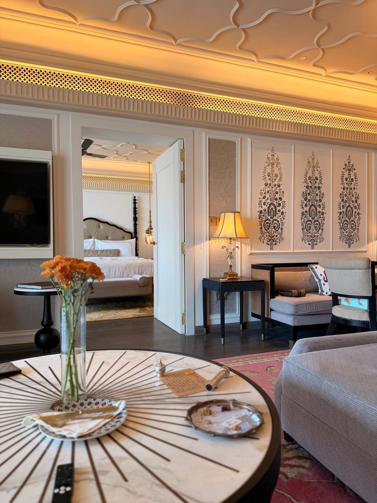 Living room of the Deluxe Suite at Fairmont Udaipur Palace, with a view through to the four-poster bedroom