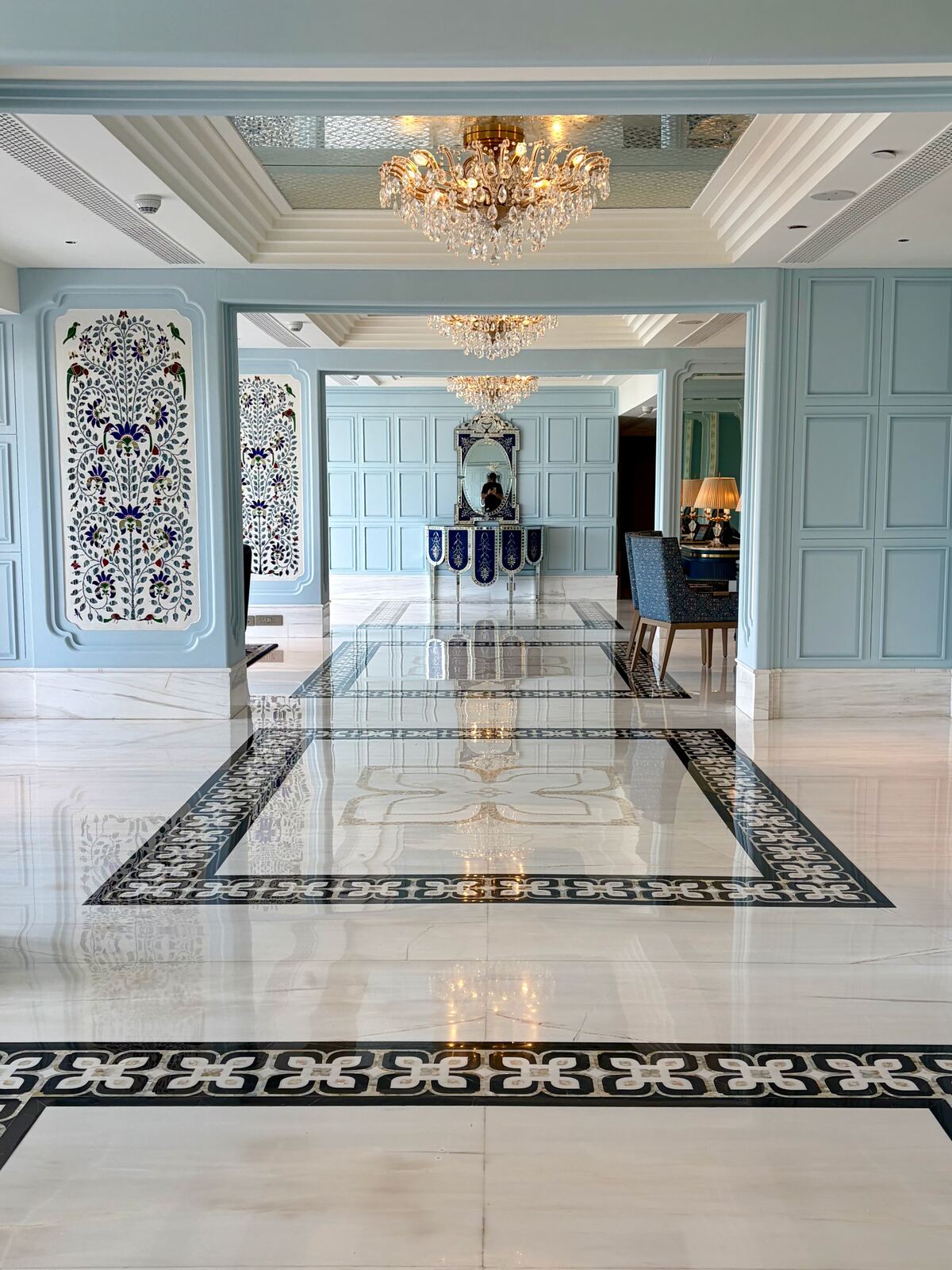 Marble corridor with inlay artwork and crystal chandeliers inside Fairmont Udaipur Palace