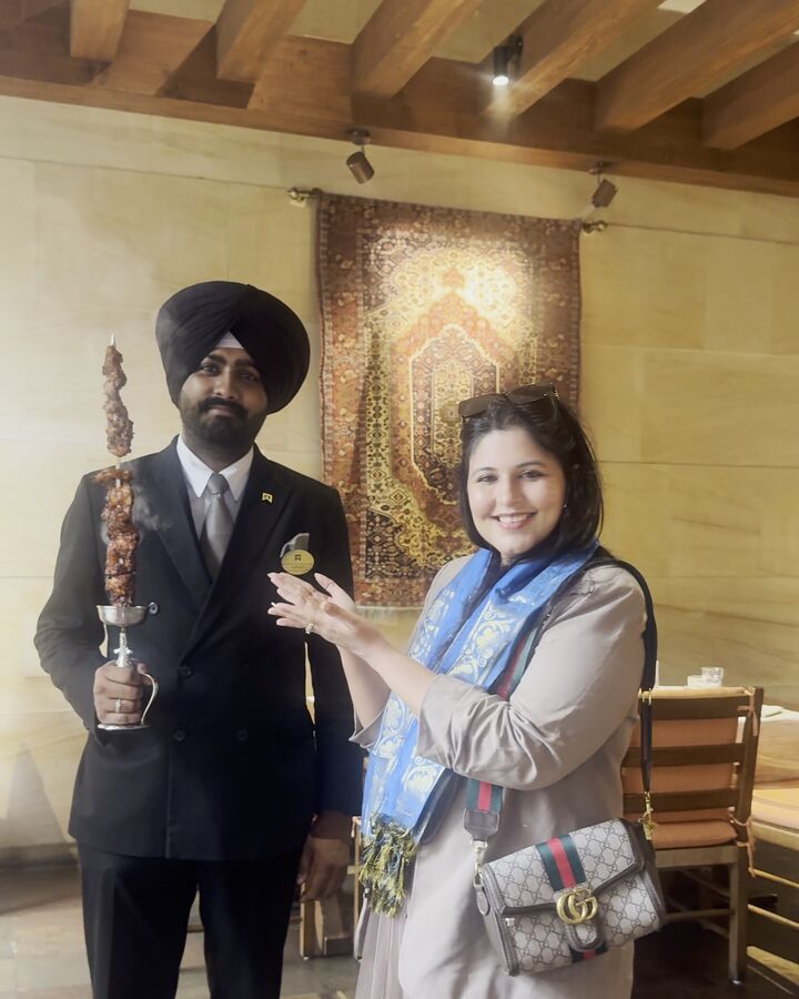 Reema posing with a smoking kebab skewer presented by staff at ITC Kakatiya's 30th anniversary celebration, Hyderabad