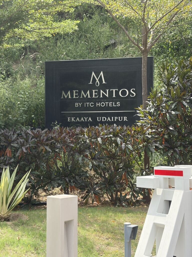 Mementos by ITC Hotels Ekaaya Udaipur entrance sign surrounded by greenery