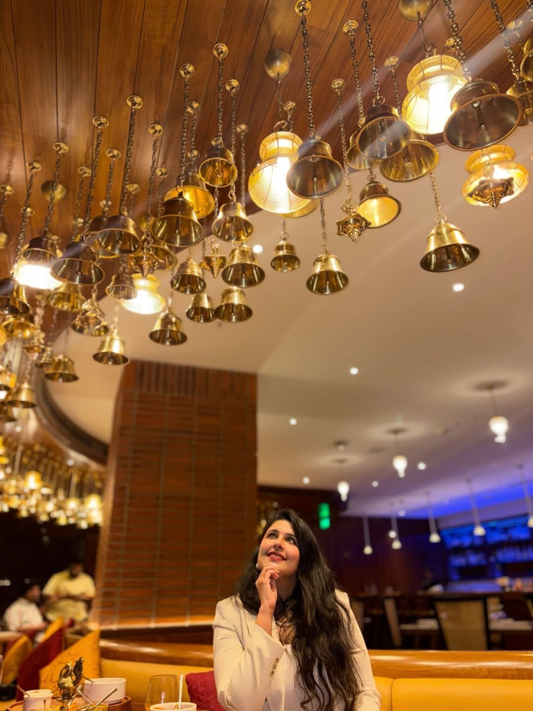 Oota Hyderabad interior with brass bell ceiling installation — Telangana fine dining restaurant decor