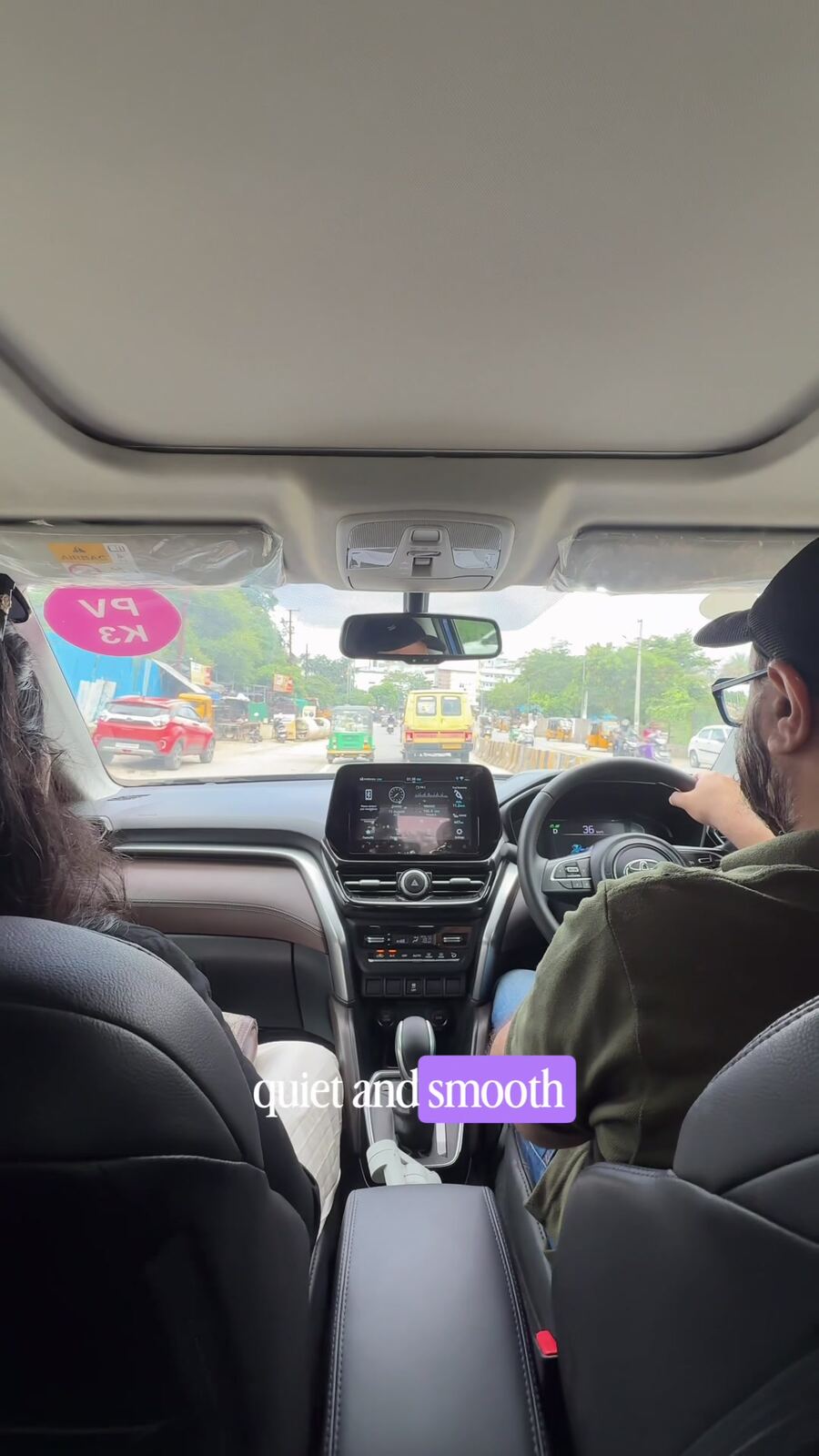 Interior view of the Toyota Hyryder self-charging hybrid driving through Hyderabad traffic, husband at the wheel