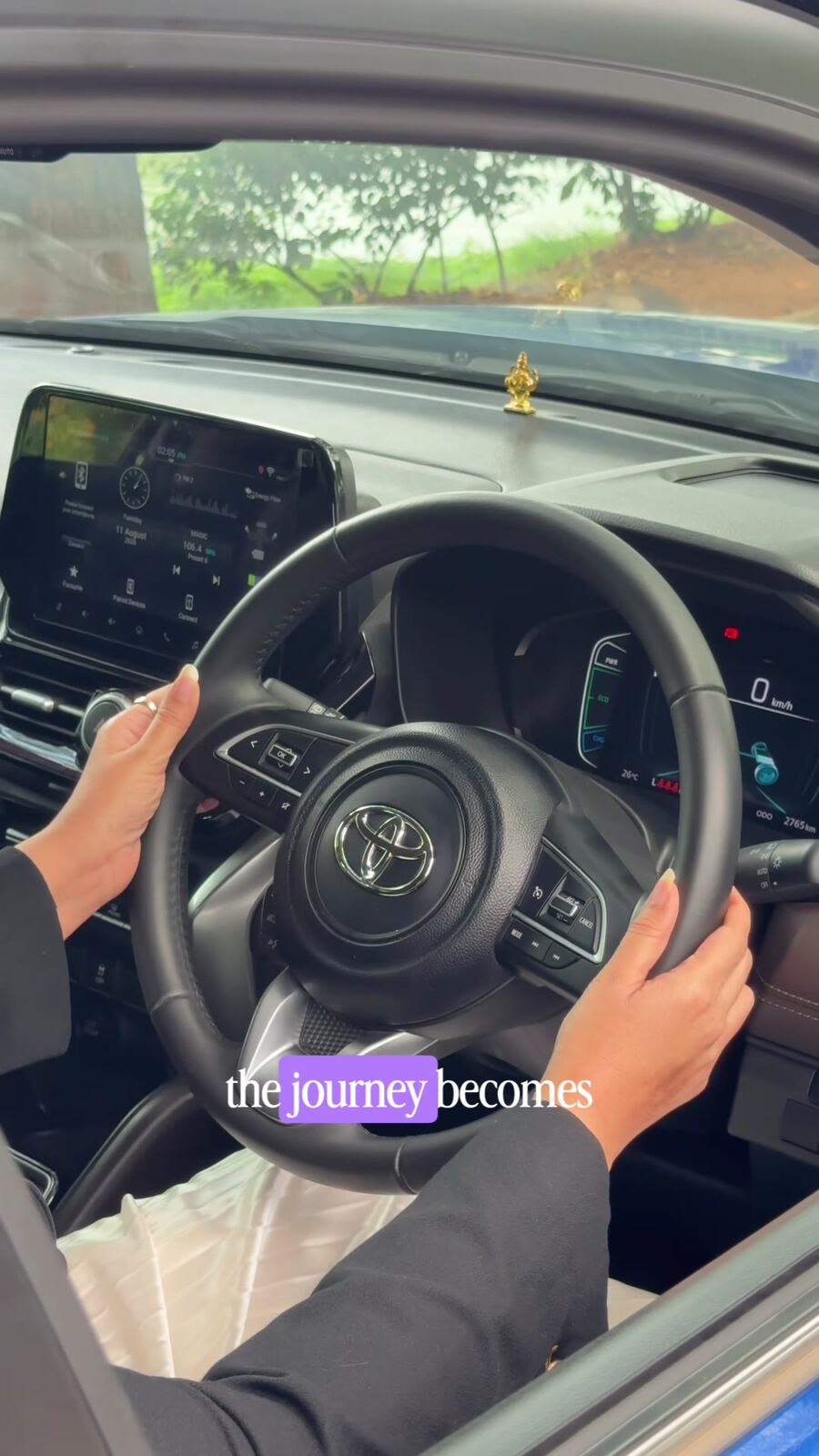 Toyota logo on the steering wheel of the Hyryder self-charging hybrid, with a small Ganesh idol on the dashboard